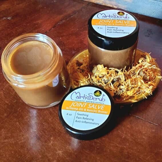 JOINT SALVE in jars with soothing ingredients for pain relief and inflammation on a wooden surface.