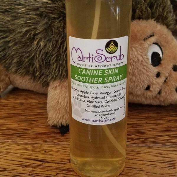 Canine Skin Soother Spray bottle with aromatherapy ingredients for dog skin relief, placed beside a plush toy.