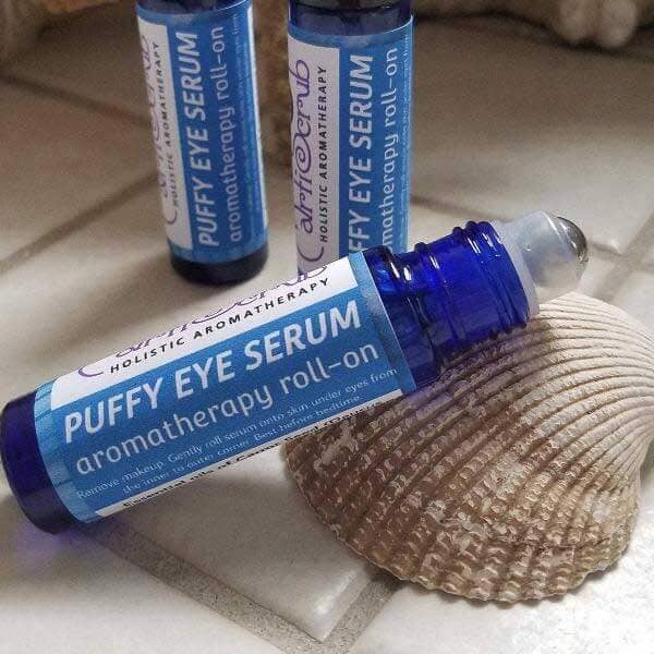PUFFY EYE SERUM roll-on bottle on a shell, showcasing its soothing and revitalizing properties for tired eyes.
