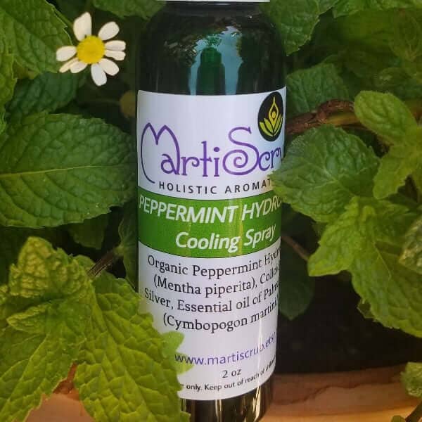 Organic Peppermint Cooling Spray bottle nestled among mint leaves, enhancing skin hydration and soothing relief.