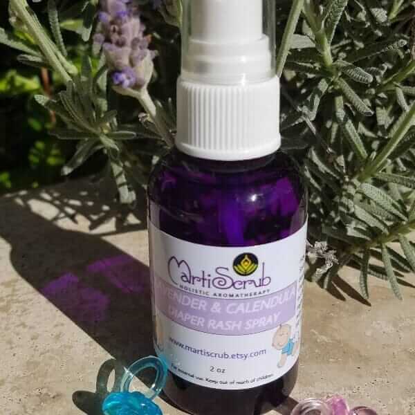 Aromatherapy diaper rash spray with organic lavender and calendula in a 2 oz PET bottle, surrounded by lavender plants.