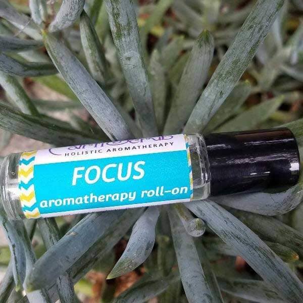 FOCUS essential oil roll-on resting on greenery, promoting clarity and focus with natural aromatherapy benefits.